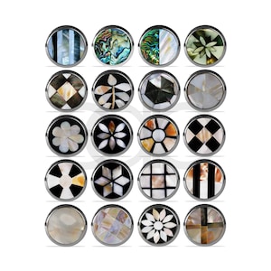 May include: A collection of sixteen round cufflinks with various inlaid designs. The designs include geometric patterns, floral motifs, and natural shell variations in colors like black, white, and iridescent hues. Each cufflink has a silver-toned metal border.
