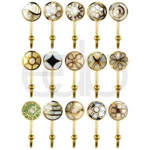 May include: A selection of decorative wall hooks with gold stems and patterned, circular tops. The tops display diverse designs with mother-of-pearl and other materials, including geometric and floral patterns. The hooks are designed for hanging items.