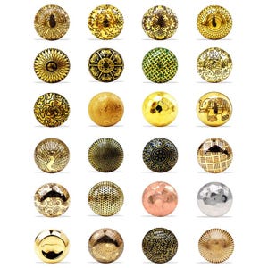 Pode incluir: Uma coleção de vinte e quatro puxadores decorativos para armários em vários designs e acabamentos. Os puxadores são principalmente dourados, com alguns apresentando padrões intrincados, texturas e alguns com tons prateados e acobreados. Os puxadores são redondos e adequados para móveis.