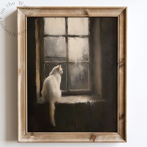 May include: A framed painting of a white cat sitting on a windowsill, looking out a window with rain falling outside. The cat is facing to the right and has a long tail.