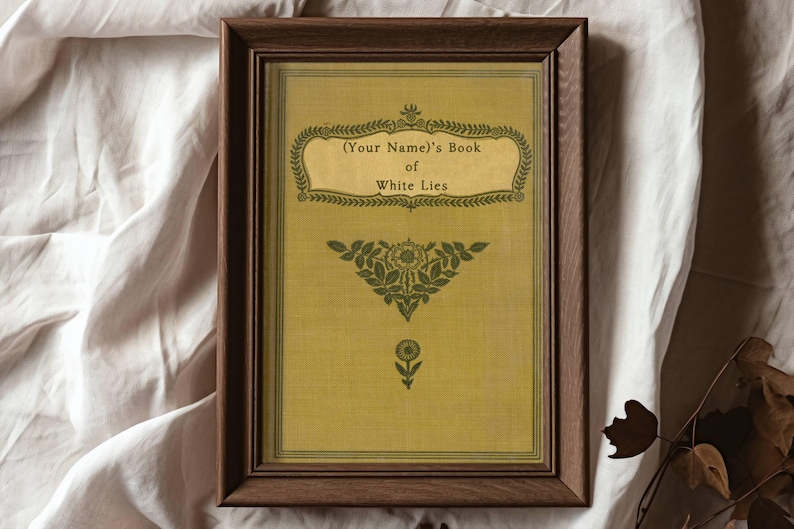 May include: A framed print with a vintage aesthetic. The print features a yellow background with green floral designs and the text "(Your Name)'s Book of White Lies".