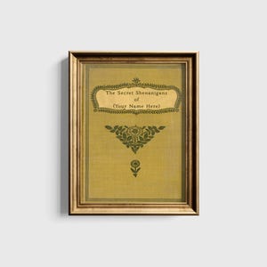 May include: A gold framed print with a yellow background and green floral design. The text reads "The Secret Shenanigans of (Your Name Here)"