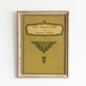 May include: A framed print with a vintage design. The print is yellow with green text and floral designs. The text reads "(Your Name)'s Guide to Peculiar Baking".