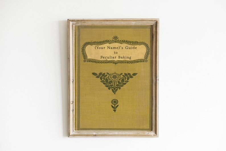 May include: A framed print with a vintage design. The print is yellow with green text and floral designs. The text reads "(Your Name)'s Guide to Peculiar Baking".
