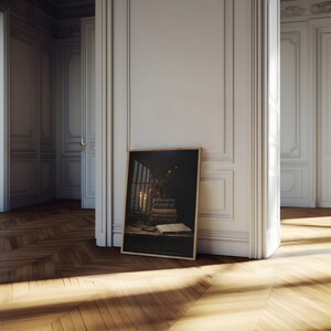 Peut inclure: Une impression encadr&eacute;e d'une nature morte repr&eacute;sentant une pile de livres, des bougies et une fen&ecirc;tre avec vue sur un jardin. L'impression est dans un cadre en bois fonc&eacute; et est appuy&eacute;e contre un mur blanc.