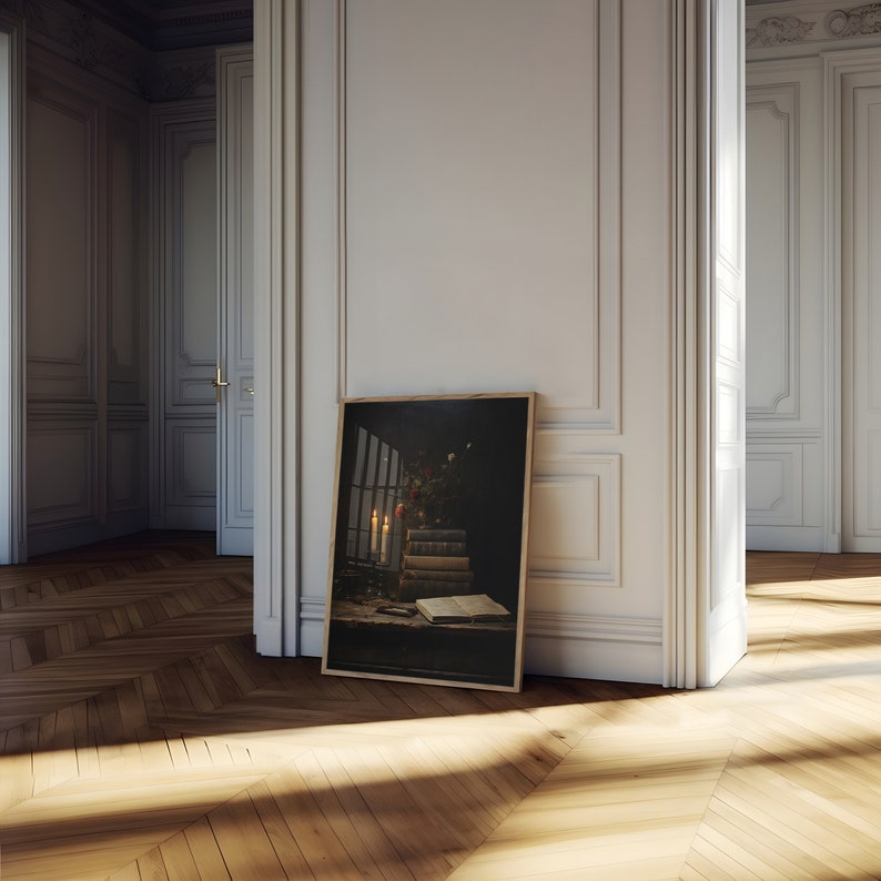 Peut inclure: Une impression encadr&eacute;e d'une nature morte repr&eacute;sentant une pile de livres, des bougies et une fen&ecirc;tre avec vue sur un jardin. L'impression est dans un cadre en bois fonc&eacute; et est appuy&eacute;e contre un mur blanc.