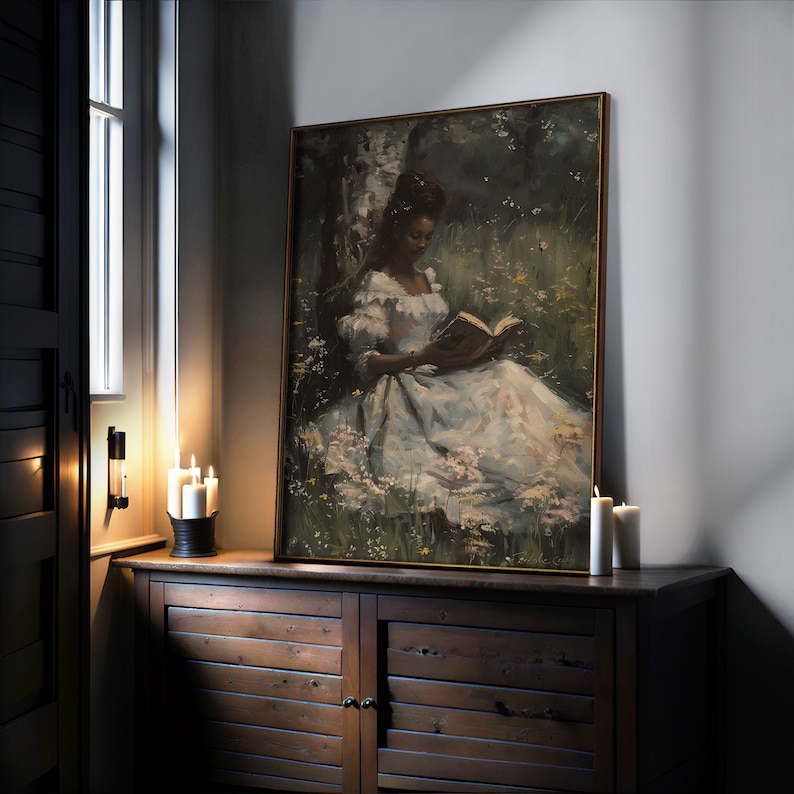 May include: A framed painting of a woman in a white dress sitting in a field of flowers and reading a book. The painting is set against a dark green background.