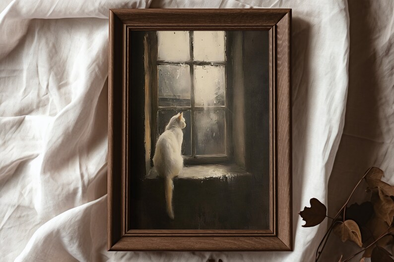 May include: A framed painting of a white cat sitting on a windowsill, looking out a window with rain falling outside. The painting is in a dark brown frame.