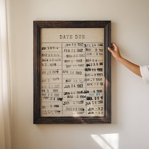 K&ouml;nnte beinhalten: Ein gerahmter Vintage-Chart mit dem Titel "Date Due" und einer Liste von Daten in schwarzer Tinte. Der Chart ist auf einem beigefarbenen Hintergrund und hat einen dunkelbraunen Rahmen.