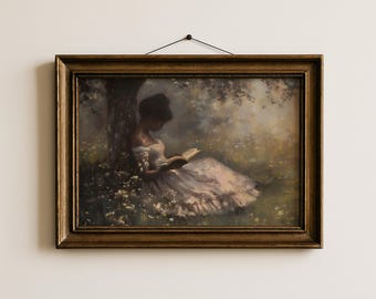 May include: A framed wall art print featuring a painting of a person in a white dress sitting under a tree reading a book in a field of flowers. The artwork is enclosed in a dark gold-toned rectangular frame with a black string for hanging.