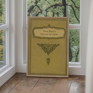 May include: A framed print of a book cover with a yellow background and green floral design. The title reads "Thea Blair's Pursuit of Calm".