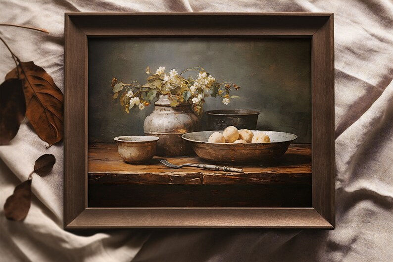 May include: A still life painting in a brown frame shows a rustic wooden table with a bowl of potatoes, a small bowl, a vase of white flowers, and a fork. The background is a muted green.