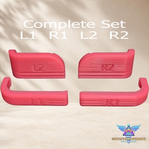 May include: A complete set of four pink controller bumper and trigger buttons labeled L1, R1, L2, and R2. The components feature a textured surface with embossed lettering and are arranged in two rows. The text Complete Set L1 R1 L2 R2 is visible above the buttons.