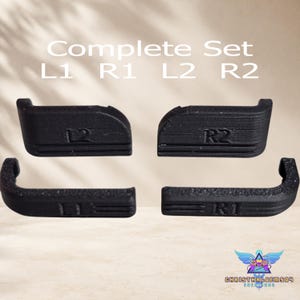 May include: A complete set of four black controller shoulder buttons labeled L1, R1, L2, and R2. The text Complete Set L1 R1 L2 R2 is visible above the buttons. Each button features a textured surface and specific ergonomic curves for gaming.