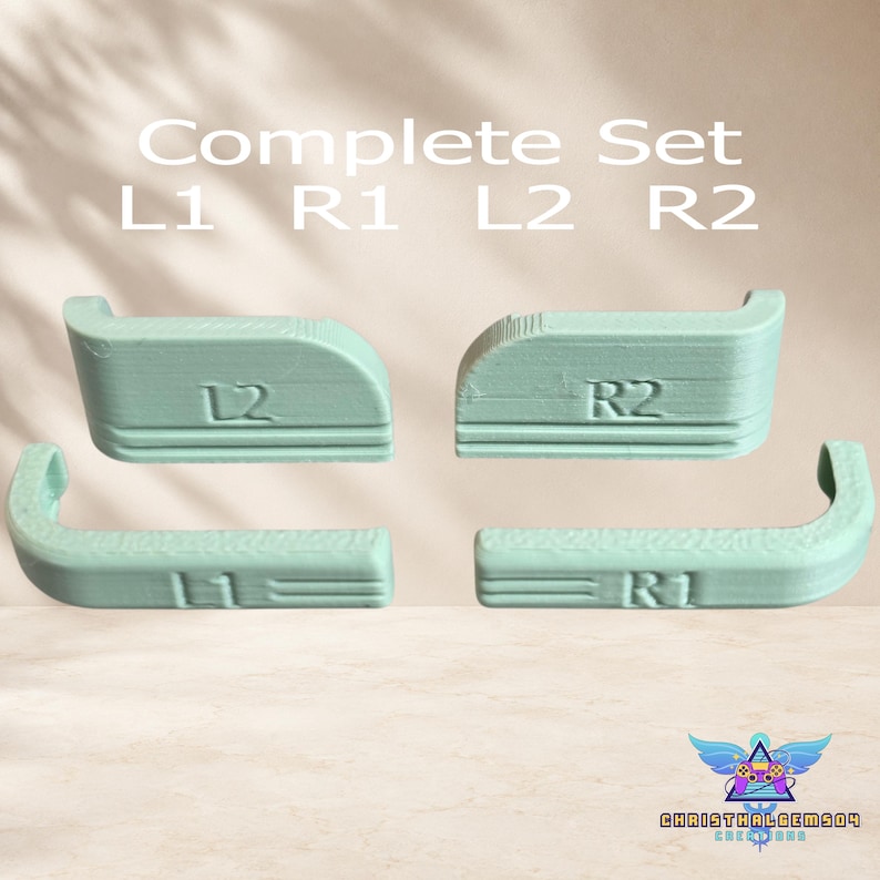 May include: A complete set of four light mint green controller trigger extensions labeled L1, R1, L2, and R2. The plastic components feature a textured surface with embossed lettering and horizontal line details, designed for gaming controller customization.