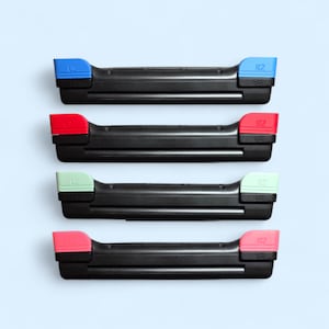 May include: Four black controller trigger assemblies arranged vertically. Each unit features a black base with L2 and R2 buttons in distinct colors: blue, red, light green, and pink. The L2 and R2 labels are clearly embossed on the top buttons.