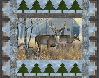 May include: A quilted blanket featuring a serene outdoor scene with two deer in a field, a cabin, and evergreen trees. The border has a log cabin design. The color palette includes shades of brown, green, and blue.
