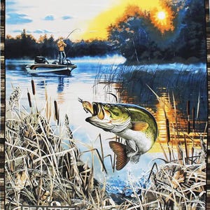 Peut inclure: Un achigan à grande bouche saute hors de l'eau avec un leurre dans la bouche. Le poisson est devant un lac avec un bateau et un pêcheur au loin. La scène se déroule au coucher du soleil avec un ciel orange vif. L'image est entourée d'un motif de camouflage brun et vert avec le texte "REALTREE" en bas.