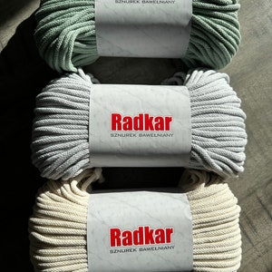 May include: Three spools of cotton rope, each with a white label that reads "Radkar SZNURĘK BAWEŁNIANY". The spools are in the colors sage green, light gray, and cream.