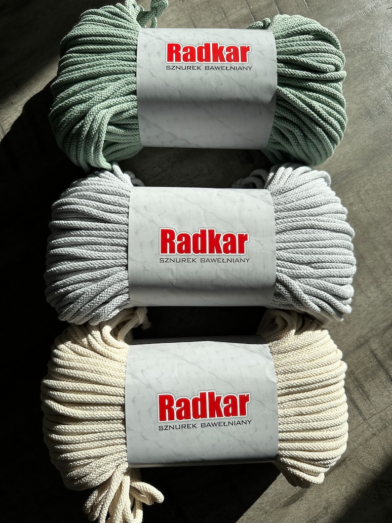 May include: Three spools of cotton rope, each with a white label that reads "Radkar SZNURĘK BAWEŁNIANY". The spools are in the colors sage green, light gray, and cream.