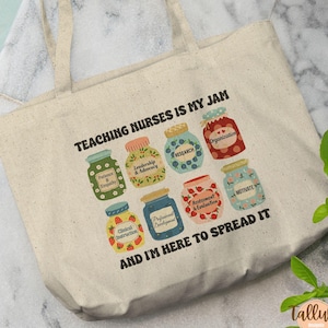 May include: A beige canvas tote bag with the text "TEACHING NURSES IS MY JAM" and colorful illustrations of jam jars. Each jar has a different label, including "Patience & Empathy" and "Research". The phrase "AND I'M HERE TO SPREAD IT" is also printed on the bag.