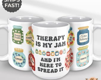 May include: White ceramic mug with the text "THERAPY IS MY JAM AND I'M HERE TO SPREAD IT". The mug features colorful illustrations of jam jars with labels like "Mental Health" and "Active Listening".