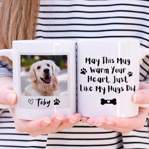 May include: White ceramic mug with a photo of a golden retriever dog and the text "May This Mug Warm Your Heart, Just Like My Hugs Did" with a paw print and bone graphic. The photo has a heart and paw print with the name "Toby" underneath.