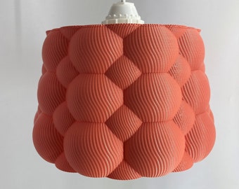 May include: A coral-colored pendant light fixture with a textured, bubble-like shade.