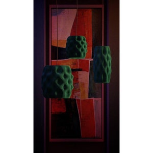 以下が含まれることがあります： 赤、オレンジ、紫の色合いの抽象画の前に、質感のある泡のような表面を持つ緑色のペンダントライトが3つ吊り下げられています。