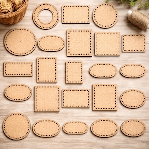 May include: A collection of various unfinished wooden craft bases in different shapes, including circles, ovals, and squares. Each piece has a series of small holes around the edges, ready for stitching or weaving. The bases are arranged on a light wood surface.