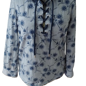 Esempio di camicetta tunica con ricami floreali e chiusura con coulisse in blu cielo