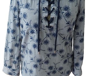 Muestra de blusa túnica con bordado floral y cierre de cordón en color azul cielo