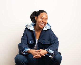 Chaqueta utilitaria única con capucha: 4 bolsillos, botones en la parte delantera y los puños, capucha, mangas y canesú trasero forrados.