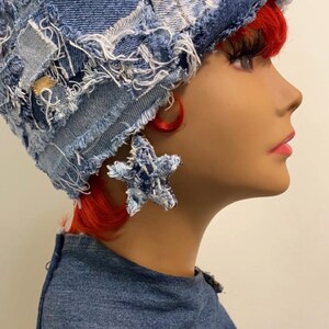 May include: A blue denim bucket hat with frayed edges and a star-shaped earring made of denim.