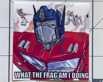 May include: A square sticker featuring a cartoon illustration of Optimus Prime in red, blue, and gray. The text "WHAT THE FRAG AM I DOING" is at the bottom. The background shows other Transformers in action.