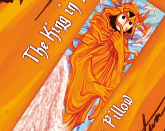 May include: A body pillow with an illustration of a figure in yellow robes and a crown, with the text "The King in Yellow" and "Body Pillow" in white script. The background is orange with a white wing.