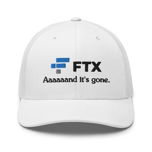 Peut inclure: Casquette de camionneur blanche avec un logo FTX bleu et gris et le texte "Aaaaaand it's gone."
