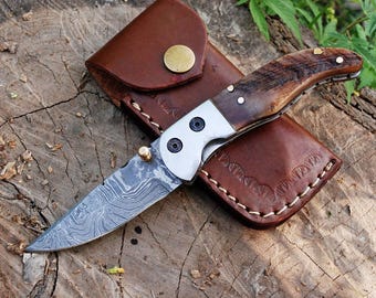 Navaja de bolsillo de acero de Damasco hecha a mano y personalizada: navaja plegable con punta caída, mango de cuerno de carnero y funda de cuero