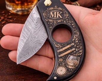 Cortapuros plegable con grabado personalizado y diseño intrincado, con funda de cuero.