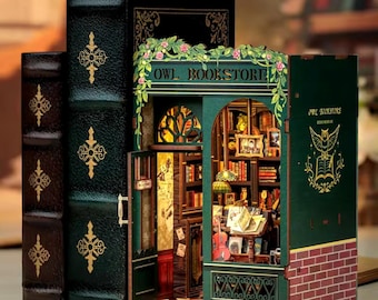 May include: A miniature wooden model of an owl bookstore with a green exterior and a sign that reads "Owl Bookstore". The bookstore has a window with a view of the interior, which is filled with bookshelves and other details. The model is made to look like a book with a green leather cover and gold accents.
