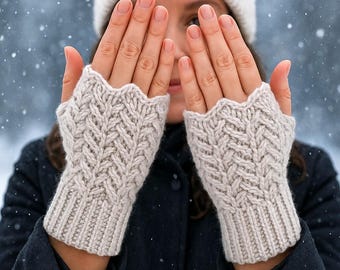 May include: A pair of beige fingerless gloves featuring a textured herringbone knit pattern, a ribbed cuff, and a scalloped top edge. The gloves are displayed against a snowy background with the text Pattern in 4 Languages visible.