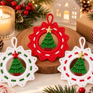 May include: Three circular crochet ornaments featuring a central green tree motif. One ornament is red with white stitching and a gold star, while two are white with green or red stitching and gold or red stars, each with a top hanging loop.