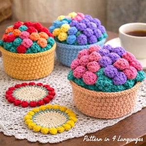 May include: Crocheted coasters and decorative baskets in various colors. The baskets are filled with colorful crocheted balls, resembling flowers. The coasters are round with a central design and a contrasting border. Text on the image reads "Pattern in 4 Languages."