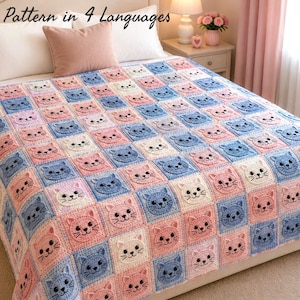 May include: A handmade crochet blanket featuring a repeating pattern of cat faces in pink, blue, and white squares. The blanket is displayed on a bed with a pink pillow. The text "Pattern in 4 Languages" is visible.