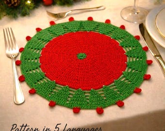 May include: A handmade, crocheted Christmas placemat in red and green. The center is red, surrounded by a green border with tree-like designs and red bobbles. The text "Pattern in 5 Languages" is at the bottom.