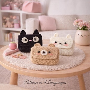 May include: Three crocheted animal-shaped coin purses: a black cat, a beige bear, and a white bunny. Each purse has a flap closure and embroidered facial features. The purses are displayed on a round wooden table with the text "Pattern in 4 Languages".
