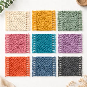 Op de afbeelding: Negen vierkante, gehaakte onderzetters in verschillende kleuren, waaronder cr&egrave;me, geel, groen, roze, turquoise, paars, oranje, blauw en grijs. Elke onderzetter heeft een getextureerd oppervlak en een franjerand. Deze handgemaakte onderzetters zijn perfect.