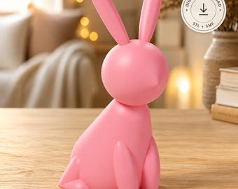 May include: A smooth, solid pink rabbit figurine with long, upright ears and a rounded body. A circular badge in the upper right corner contains the text DIGITAL DOWNLOAD with a downward arrow icon and the labels STL + 3MF.