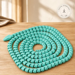 Puede incluir: Un juguete de serpiente articulada de color turquesa con un cuerpo segmentado enrollado en espiral. El objeto presenta un acabado mate liso y una forma de cabeza distintiva. Una insignia circular en la esquina superior derecha muestra el texto DIGITAL DOWNLOAD, un icono de flecha y los formatos de archivo STL + 3MF.
