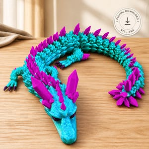 May include: A 3D printed articulated dragon figure in bright turquoise with vibrant purple crystal-like spikes along its back and head. A circular badge in the corner displays the text Digital Download, STL + 3MF, and a downward arrow icon.